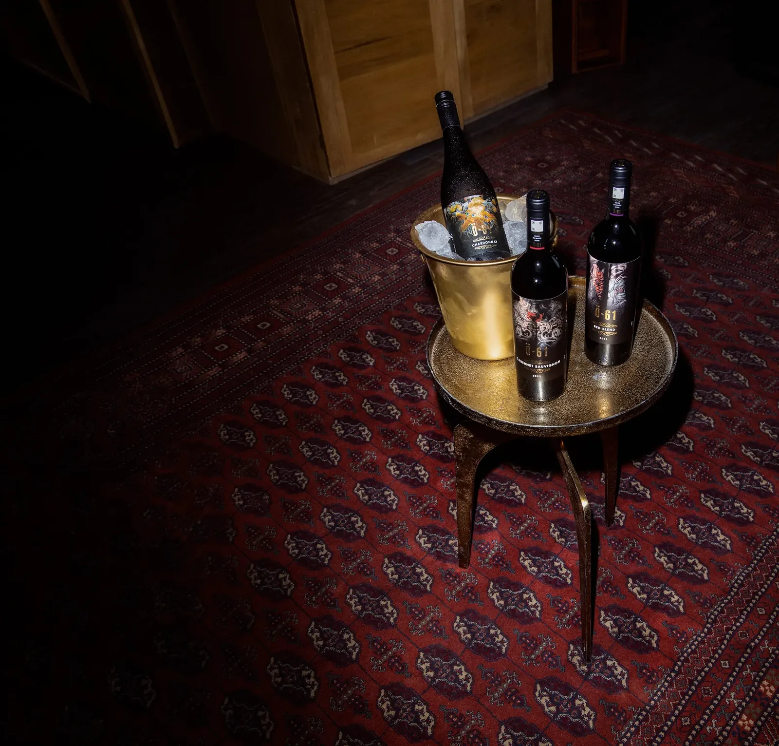 Ö-61 bottles on a brass table next to a gold ice bucket